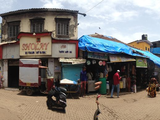 Old structure with shops lined up on the ground floor and community space on the first. 