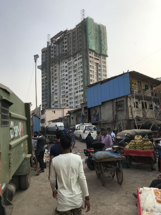 Informal settlements with an incomplete redevelopment building in the background