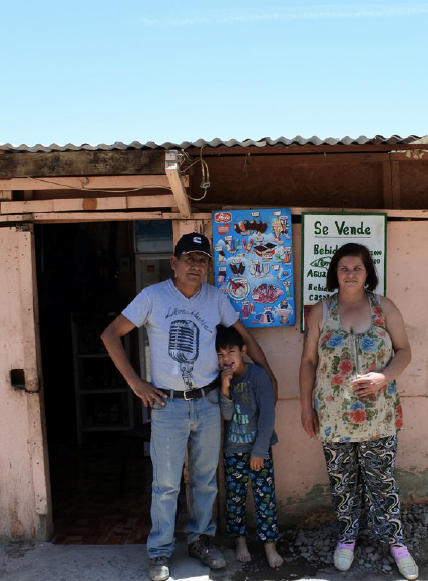 Residents of a Campamento in Chile in front of their home  
