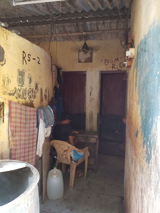 The entrance to the "Gents" section of the toilet block where the person in-charge of maintenance sits