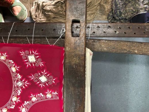 The cloth stretched across the wooden frame, using string and nails.